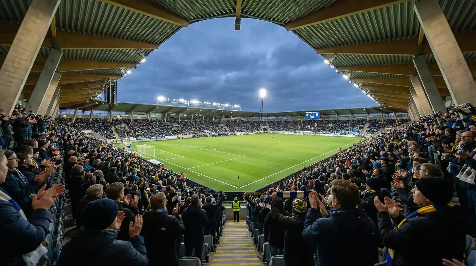 Fullsatt Allsvenskan-arena med engagerade fans under en hemmamatch i svensk fotboll
